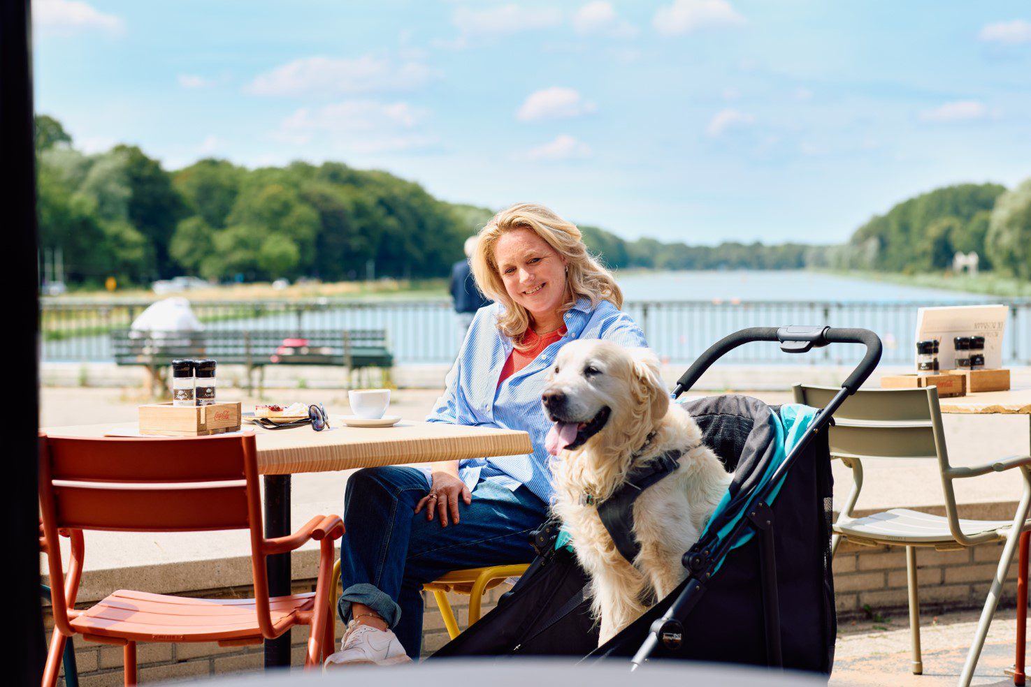 vrouw met haar senior labrador op een terras in een innopet hondenbuggy mamut speciaal gemaakt voor zware honden